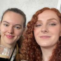 Alums smile holding glasses of Guinness